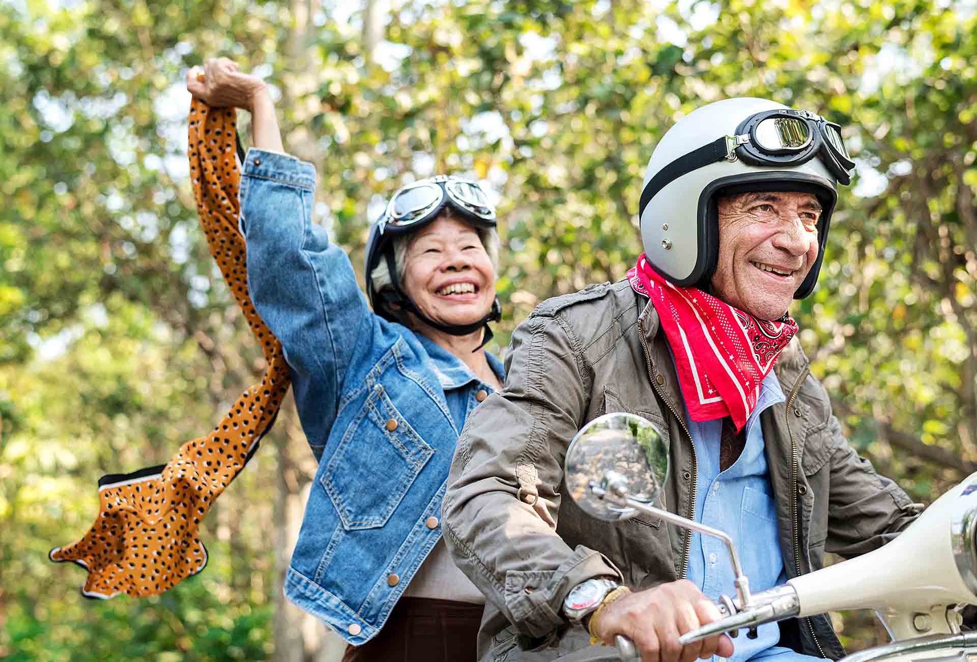 Senior couple riding a classic scooter Senior couple riding a classic scooter