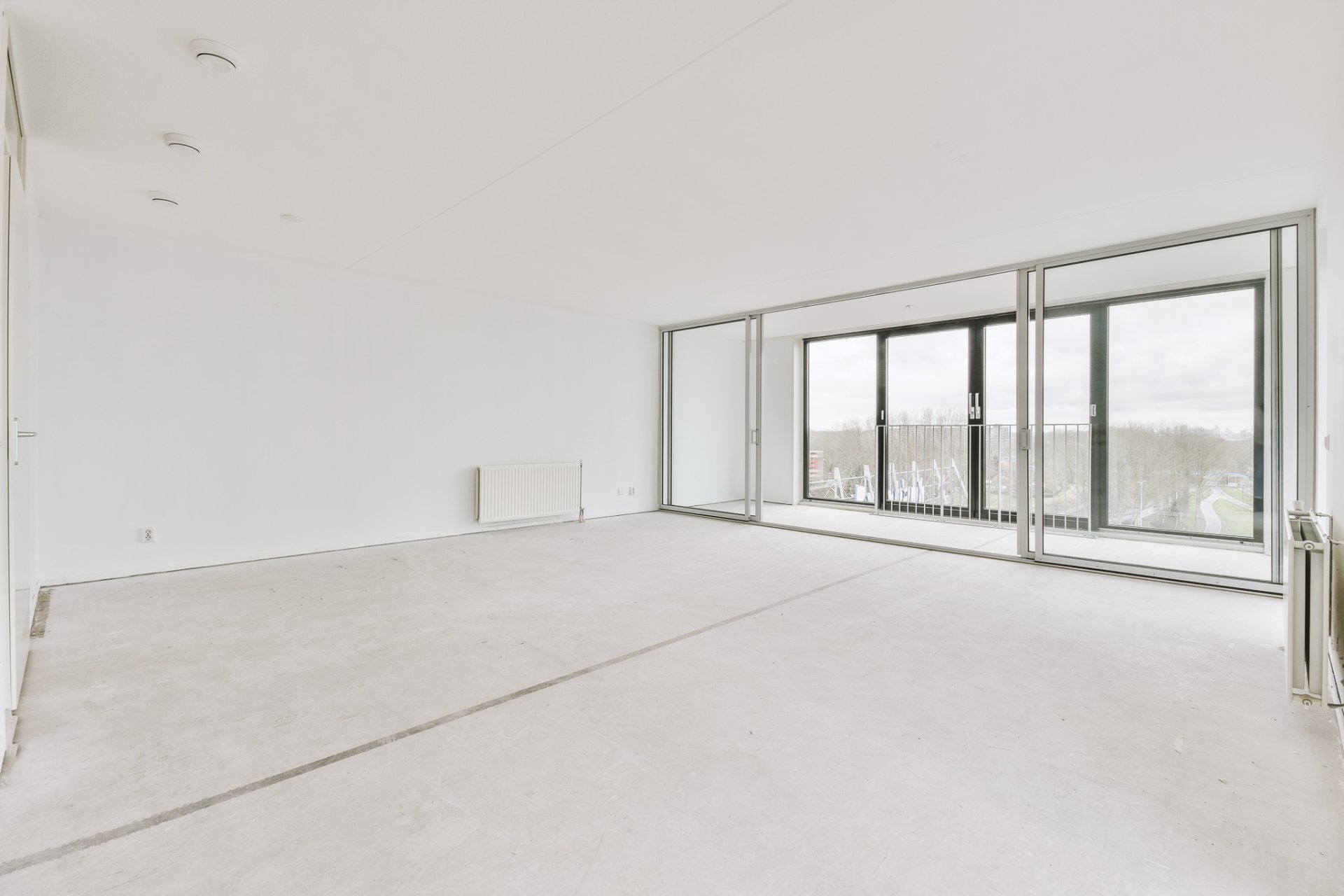 Spacious, empty, bright room with access to a glazed balcony