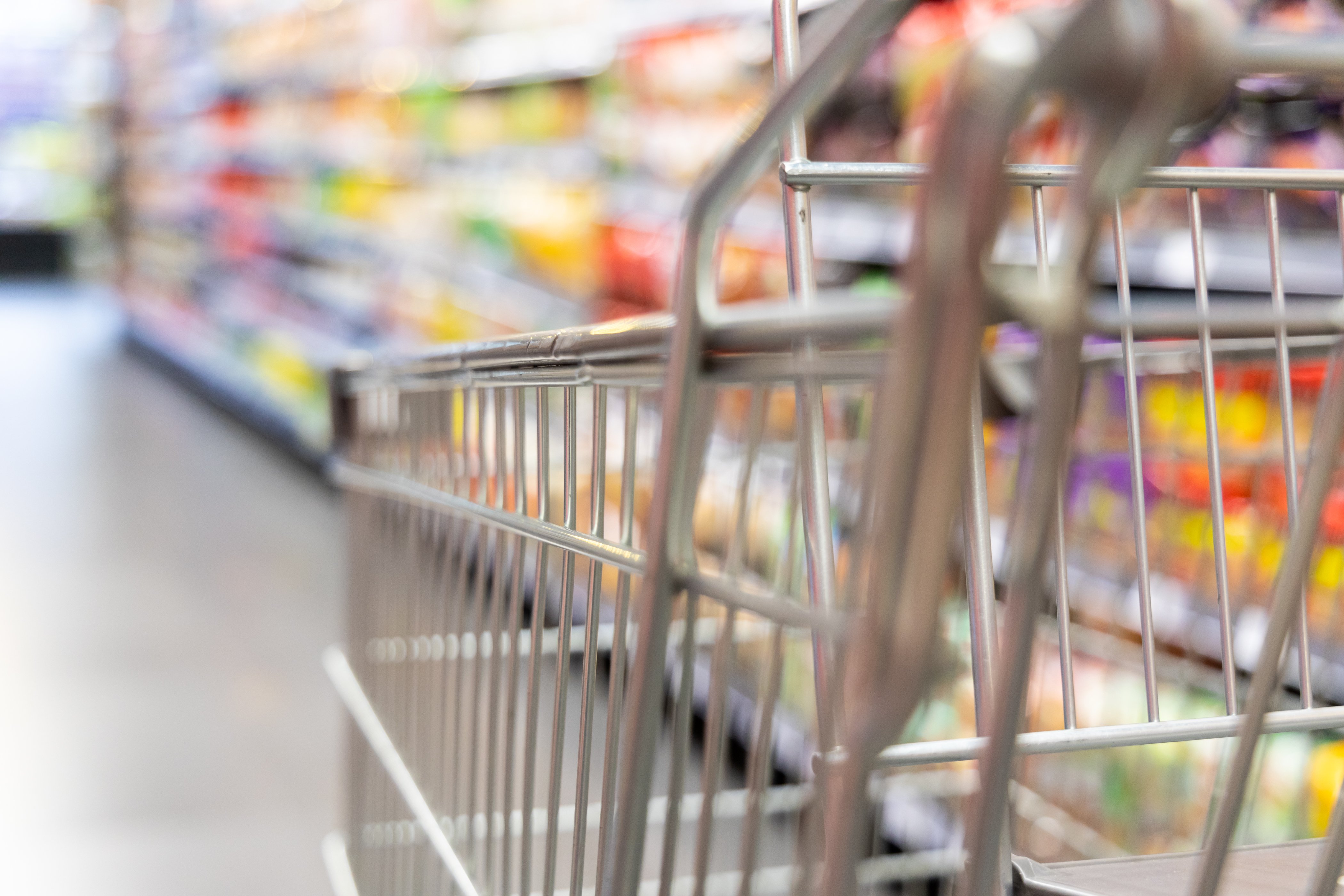 Shopping trolley cart with shallow DOF against supermarket aisle