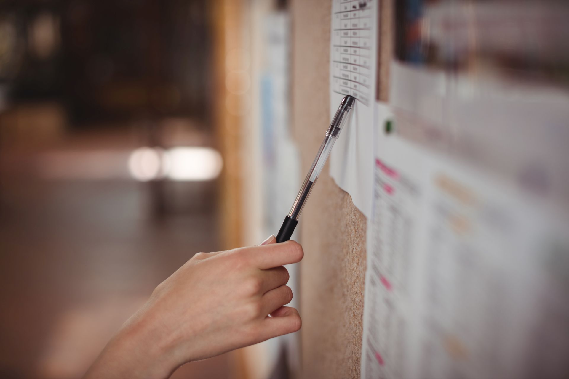 Schoolgirl looking at notice board in corridor