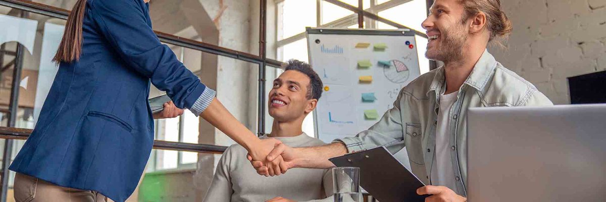 Business people finishing up a meeting. Man shaking hands with female client