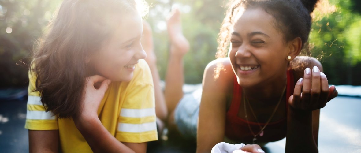 Front view of young teenager girls friends outdoors in garden, laughing.