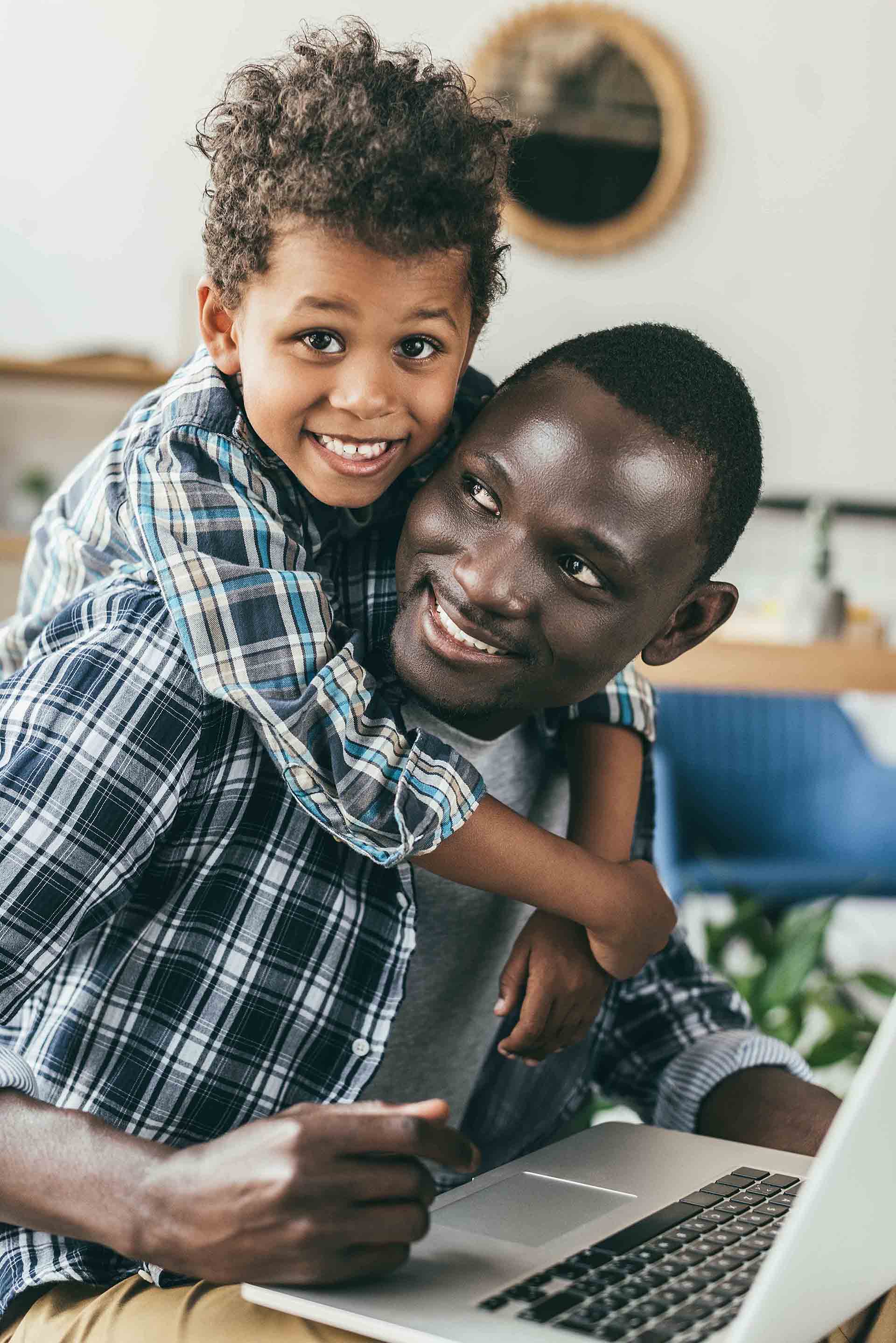 handsome father spending time with smiling son and working with