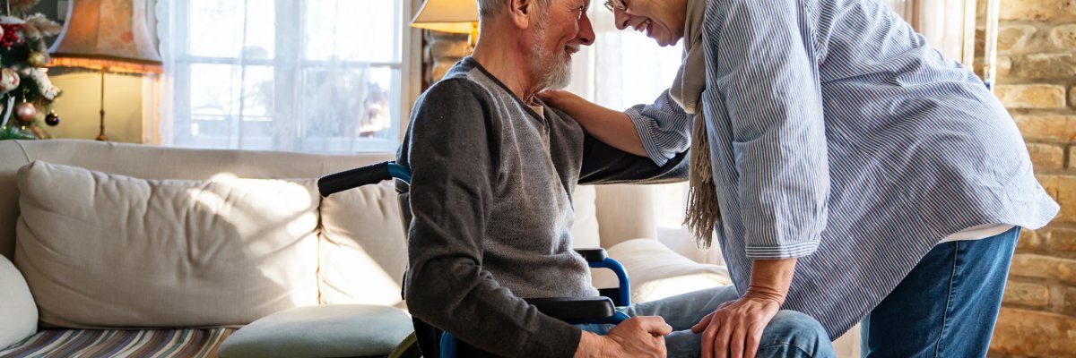 Mature man with disability in wheelchair having fun with wife. Family senior couple love concept