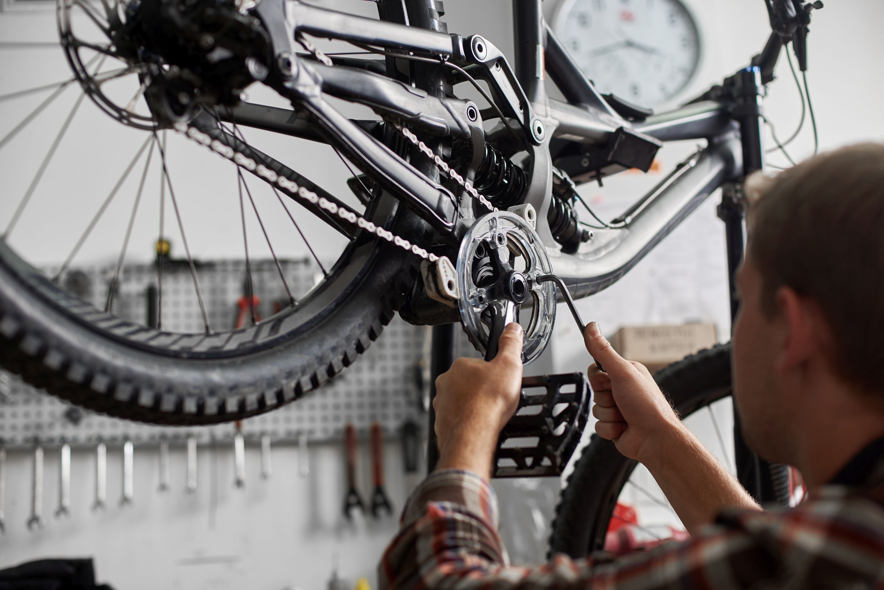Male mechanic working in bicycle repair shop using tools