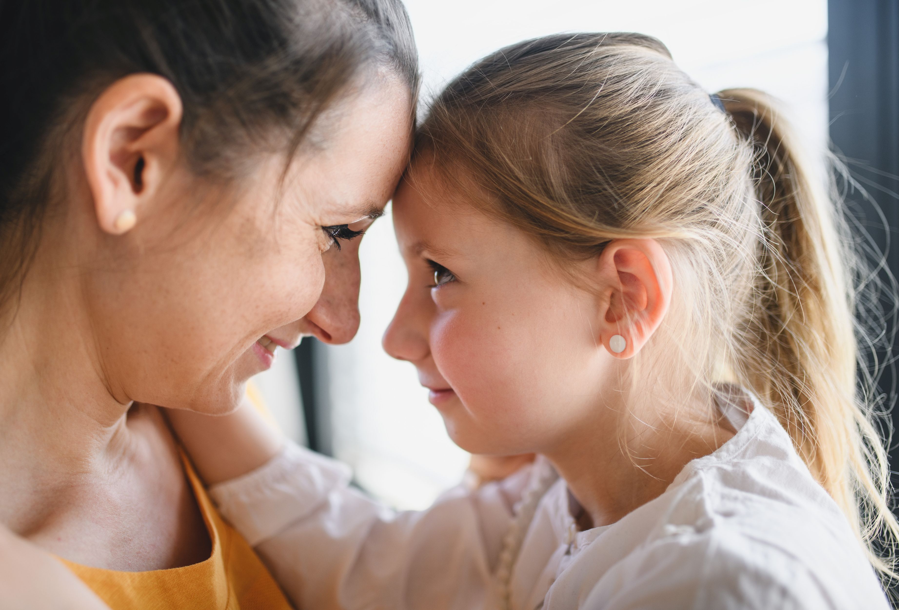 Mother and child indoors at home, hugging. Mother and child indoors at home, hugging.