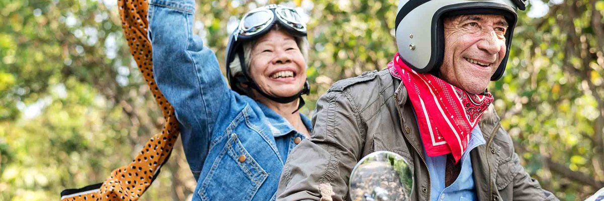 Senior couple riding a classic scooter