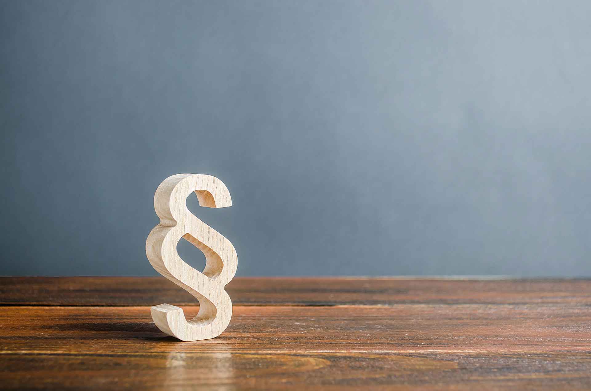 A wooden paragraph figurine. Justice and judicial system concept. Legal assistance, services of lawyers. Democratic institutions, human rights and property. Legislation and lawmaking.