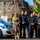 Gruppe der Stadtpolizei steht vor zwei Stadtpolizeiautos vor der Burg