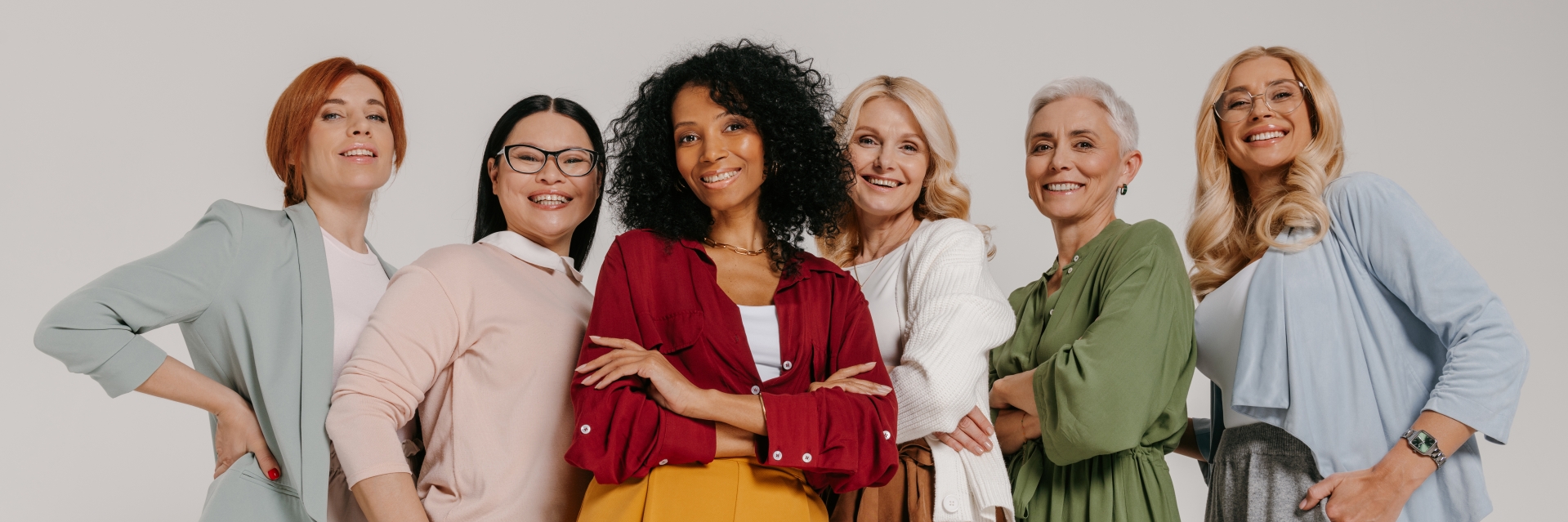 Group of elegant mature women bonding and smiling against grey background Group of elegant mature women bonding and smiling against grey background