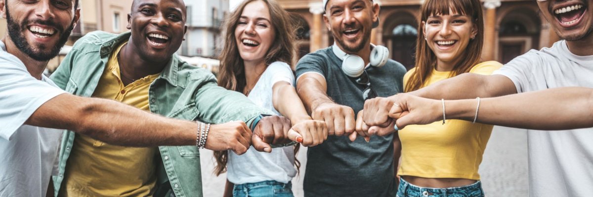 Multiracial group of young people making fist bump as symbol of