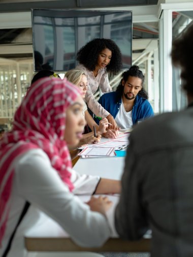 Front view of diverse business people discussing together over documents at conference room in a modern office