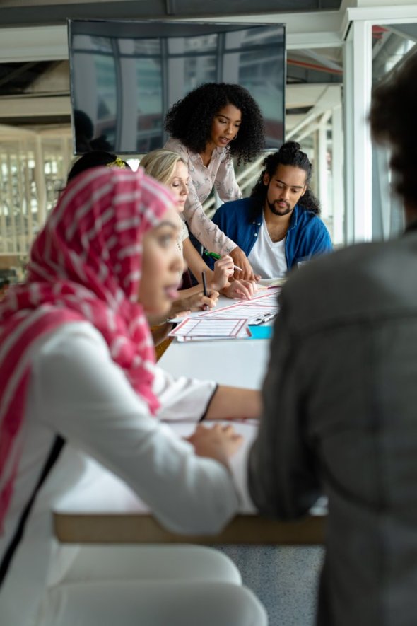 Front view of diverse business people discussing together over documents at conference room in a modern office