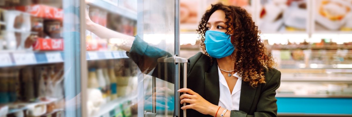 Young woman wearing face mask buying in supermarket. Shopping during the pandemic. Covid-2019.